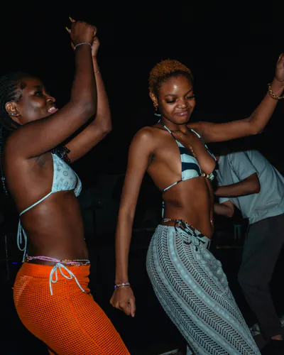 Stock photo: three people dancing by a pool at night.