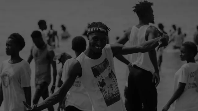 Stock photo in black and white: young people dancing on a beach.