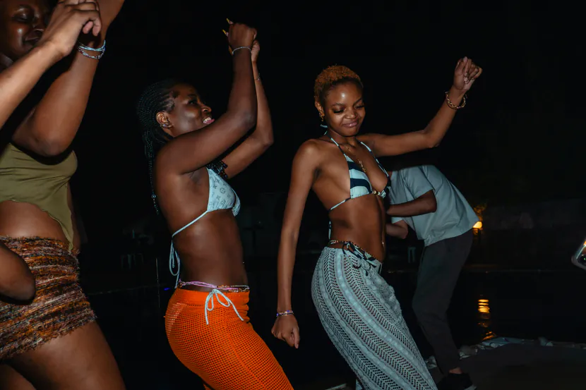 Stock photo: three people dancing by a pool at night.
